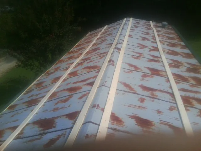 Rusted metal roof panels with new wood purlins before replacement — Storm Damage Roof Repair in Garvin by Roofing Brothers