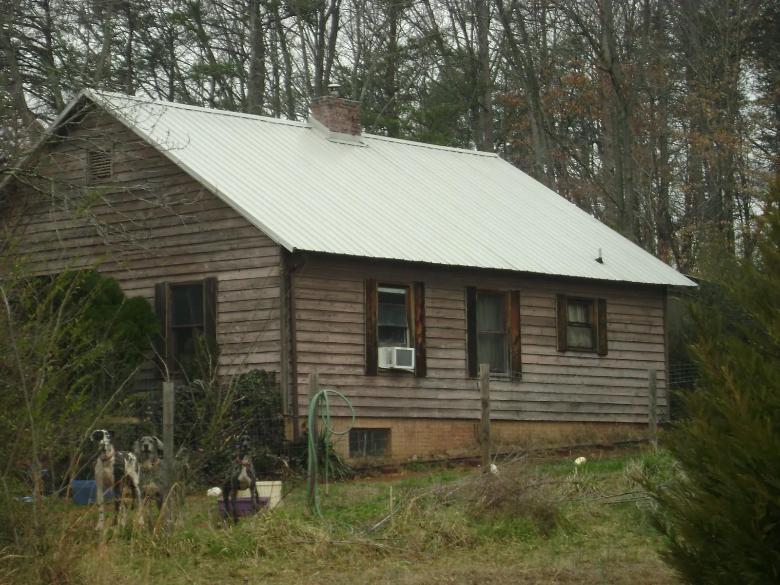 White metal roof on an old wood sided farmhouse, from a Asphalt Shingle Roof Repair job in Garvin