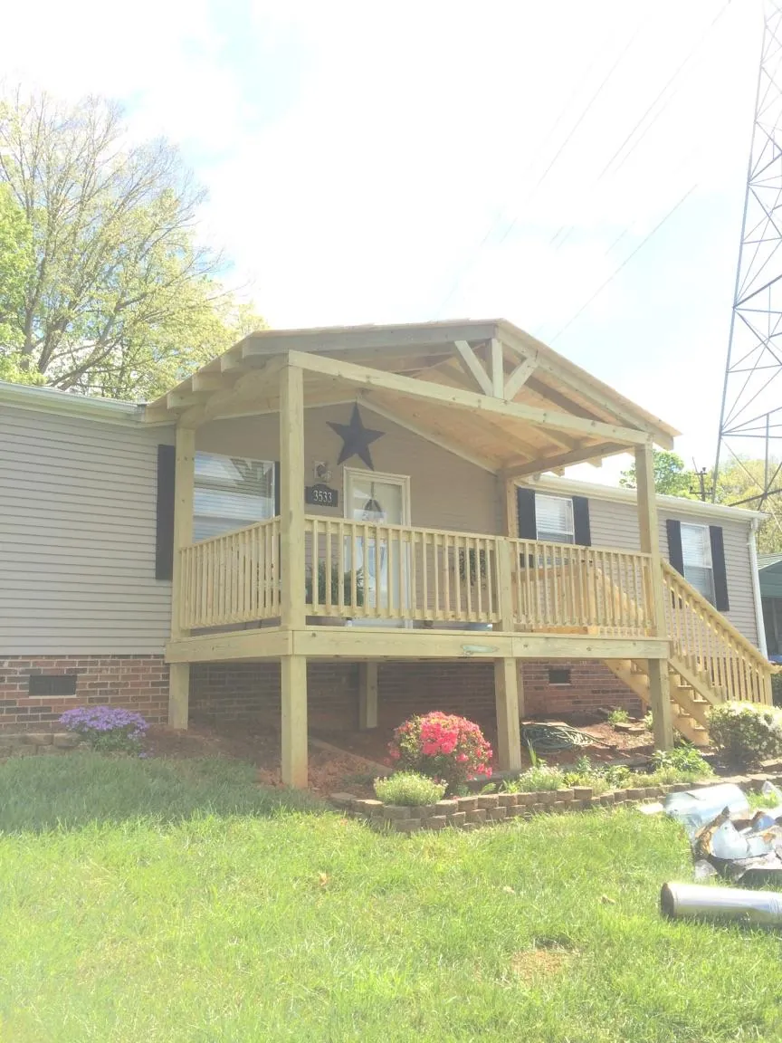 New gabled porch roof and deck railing added to a ranch home in Garvin